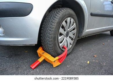 Parked Car With A Yellow Tire Lock. Wheel Lock For Illegal Parking Violation On The Street. 