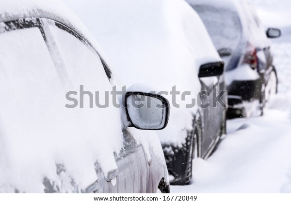 Parked cars covered with\
snow