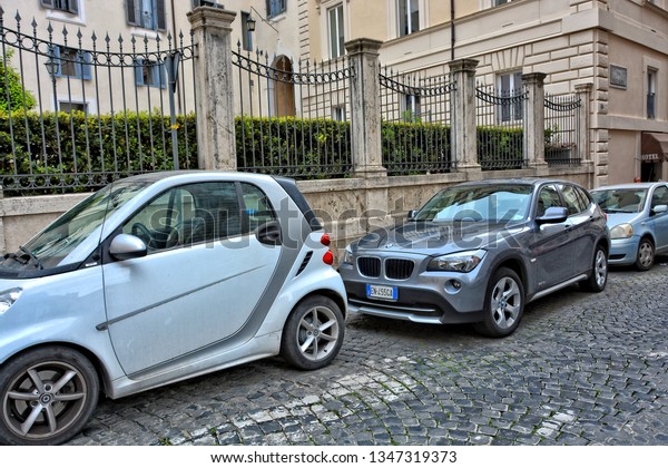 Parked cars.\
Modern life in Rome. Italian street. Cobblestone road. Urban\
landscape. Italy, Rome – April 18, 2018 \
