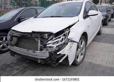 A parked crashed white car at street with broken headlights and front view - Shutterstock ID 1671193801