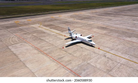 Parked Expensive Private Airplane On Concrete Ground Of Airport, Aerial. Small Business Jet Parked On The Runaway