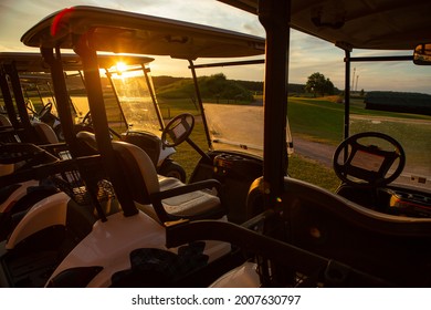 Parked Golf Carts At Sunset. Electric Car For Driving On The Golf Course 