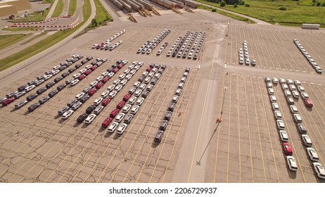 Parked New Cars At The Car Automotive Plant Manufacturer Lot. Electric Hybrid Cars Vehicle Factory. Aerial. Almost Empty Stock. Broken Supply Chain And Chip Shortage Lead To Car Shortage Availability