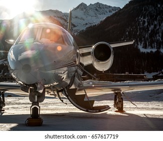 Parked at Samedan Engadin Airport over snow park at the last light of day. Private bizjet airplane used by businessmen, VIP and rich people to move around the world. - Powered by Shutterstock