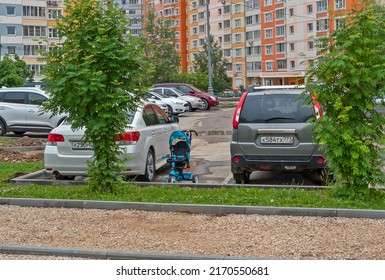 A Parked Stroller Between Two Parked Cars