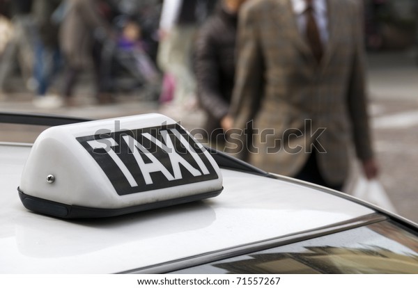 Parked\
taxi car roof detail, selective focus on taxi\
sign