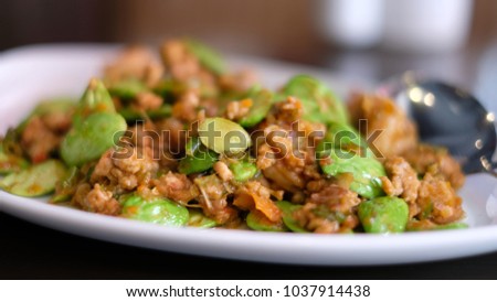 Parkia stirred fry on a plate with blurred spoon