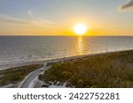 Parking lot at Blind Pass beach on Manasota Key in Englewood. Tourists cars in front of ocean beach with soft white sand in Florida. Popular vacation spot at sunset