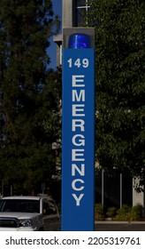 Parking Lot Blue Light Emergency Call Box Sign Pole With Green Tree Background