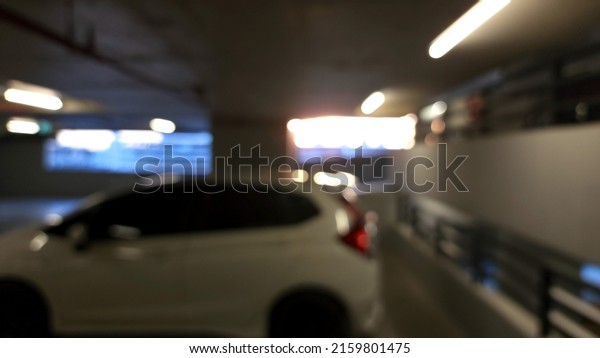 Parking car blurred. Empty road asphalt\
background in soft focus. Car lot parking space in underground city\
garage. Interior underground\
carpark.