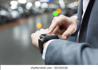 In parking car a man using his smartwatch. Close-up hands