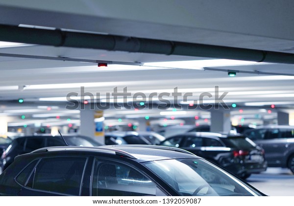 Parking cars without people. Many cars in\
parking garage interior, industrial building. Underground parking\
with cars. Toning.\
Blurred.