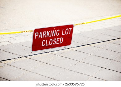 Parking Lot Closed red rectangular sign suspended on a chain blocking access to an empty public parking lot at a corporate campus, sunny day, no people, copy space
