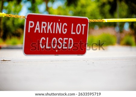 Parking Lot Closed red rectangular sign suspended on a chain blocking access to an empty public parking lot at a corporate campus, sunny day, no people, copy space
