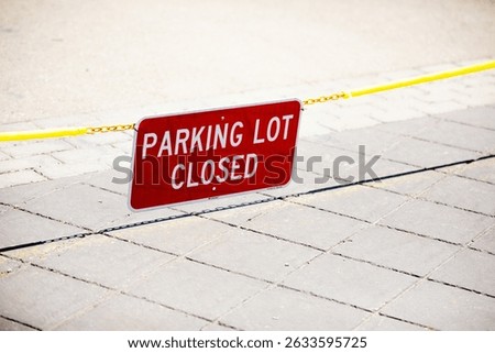 Parking Lot Closed red rectangular sign suspended on a chain blocking access to an empty public parking lot at a corporate campus, sunny day, no people, copy space