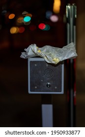 A Parking Garage Intercom. On Top Rests A Discarded Wax Paper Wrapper For Food.