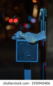 A Parking Garage Intercom. On Top Rests A Discarded Wax Paper Wrapper For Food.