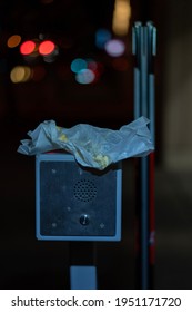 A Parking Garage Intercom. On Top Rests A Discarded Wax Paper Wrapper For Food.