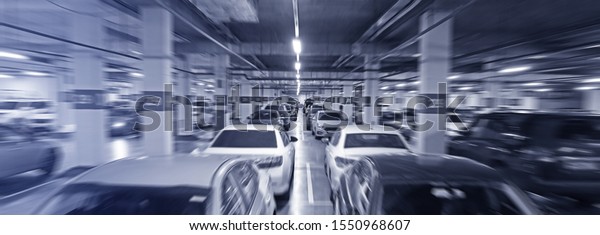 Parking garage - interior blurred of multi-story car\
park, underground parking with cars.                               \
