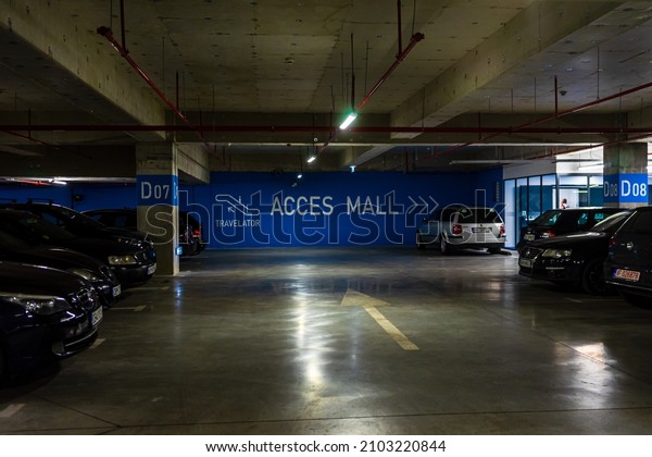 Parking garage interior with\
a few parked cars. Underground parking garage in Bucharest,\
Romania, 2022