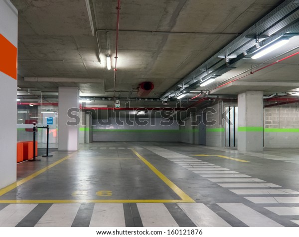 Parking garage underground,\
industrial interior.  Neon light in bright industrial\
building.
