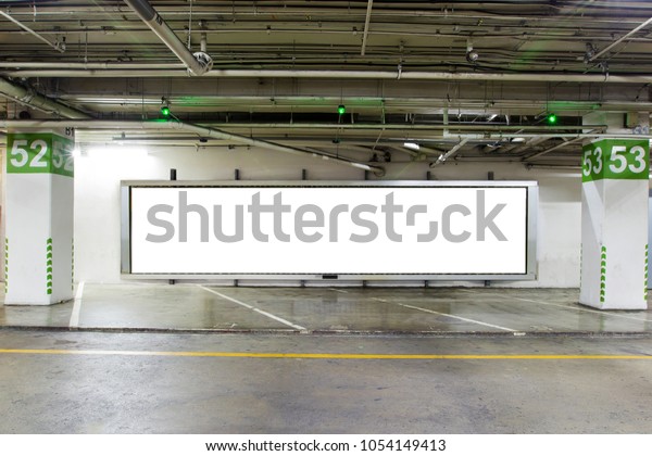 parking garage underground interior with blank\
billboard.Empty space car park interior at night.Indoor parking\
lot.interior of parking garage with car and vacant parking lot in\
building.