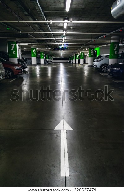 Parking garage underground interior,\
direction sign - arrow, modern public\
construction
