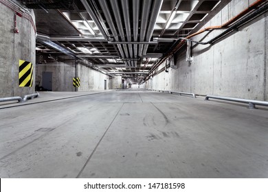 Parking garage underground interior, neon lights in dark industrial building, modern public construction