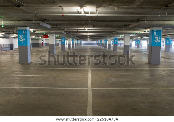 Parking garage
underground interior, neon lights in dark industrial building,
modern public
construction