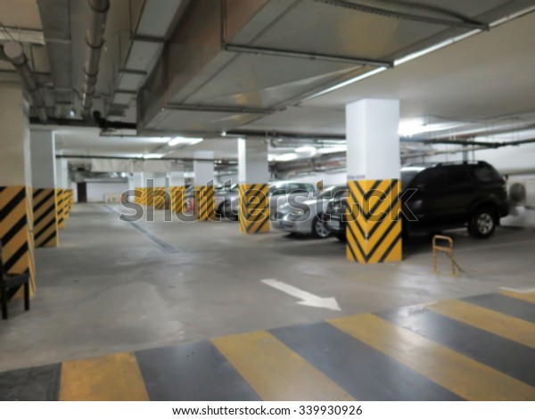 Parking garage, underground interior with a parked cars\
and people. Intentional motion blur                              \
