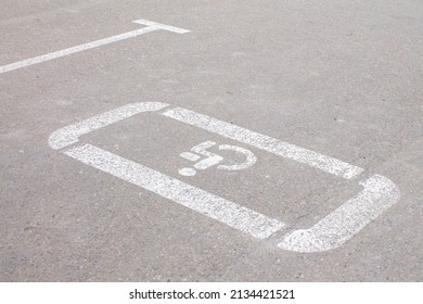 Parking lot with handicap sign and symbol. Empty reserved parking space with wheelchair symbol. Disabled person sign.