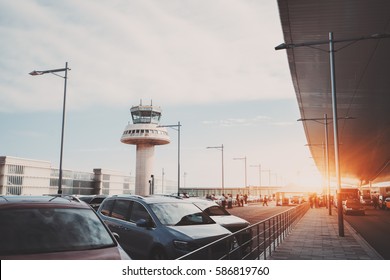 Parking Lot, Road And Cabstand Near Modern Contemporary Airport Terminal In Front Of Air Traffic Control Tower, With Many Passengers And Staff Passing In Distance, Barcelona, Spain