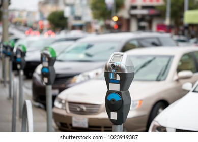 Parking machine with electronic payment in the city streets and a row of cars