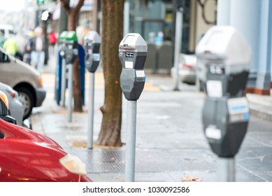 Parking machine with electronic payment in the city streets and a row of cars

