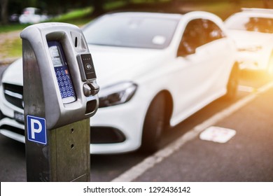 Parking machine or Parking meters with electronic payment in the city streets and a row of cars in Sydney Australia.
