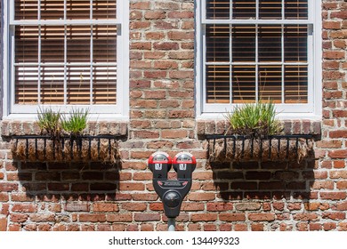 Parking Meter Between Windows in Brick Wall