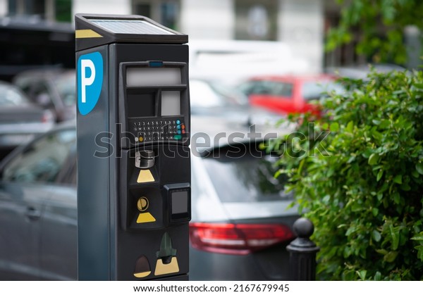 Parking meter on city street, space for text.\
Modern device