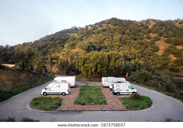 Parking of motorhomes and campers in the
forest. Andalusian landscape. South of
Spain.