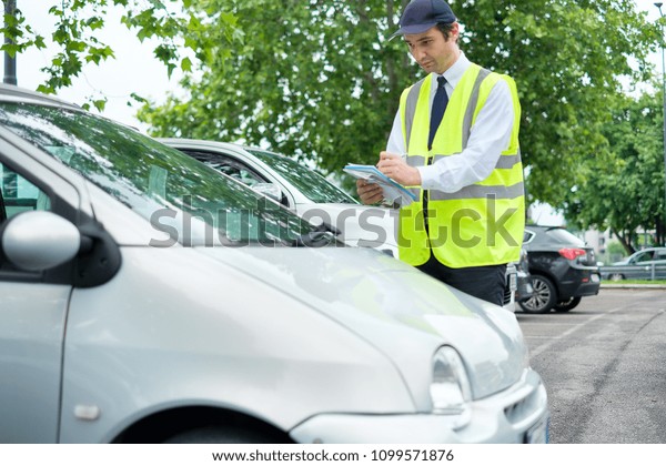 Parking\
officer writing a ticket for a parking\
violation