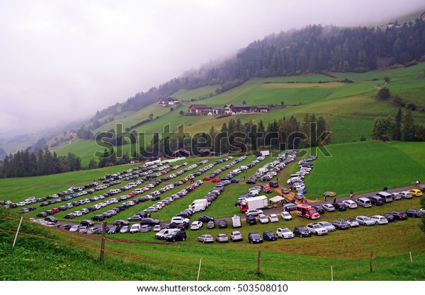 parking on the grass in the\
mountains car on the occasion of a holy Magdalene Speck festival in\
South Tyrol in Val di Funes craft markets and grocery\
products
