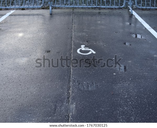 Parking lot with painted sign of wheelchair.\
Parking spaces for disabled\
customers.