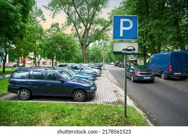 Parking lot sign, cars parked under green trees in residential area, Parking zone. Parking problems not enough free space. Crowded public parking lot on narrow street. Rows of cars parked on roadside - Shutterstock ID 2178561523