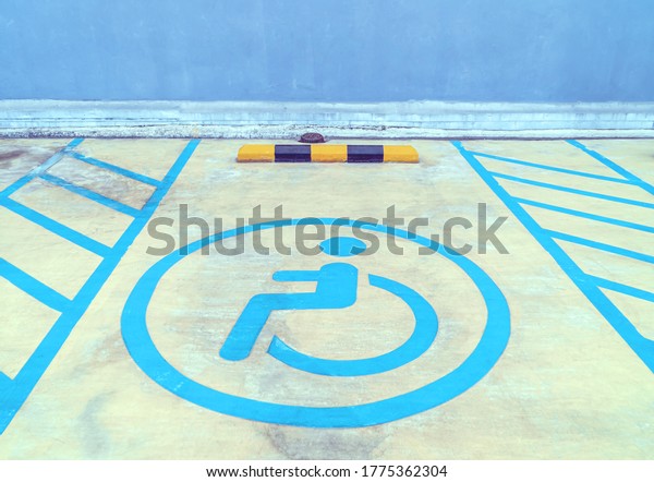 Parking\
signs for the disabled on the parking lot floor, Disability sign in\
car park in shopping mall concept, Graphic of a person sitting in a\
wheelchair symbol on grey ground in parking\
lots.