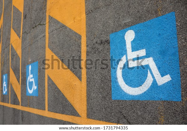 parking with space reserved for\
disabled people and the large colored pictogram on the\
asphalt