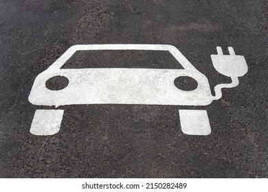 Parking space reserved for electric car. Asphalt marked with a car and plug.