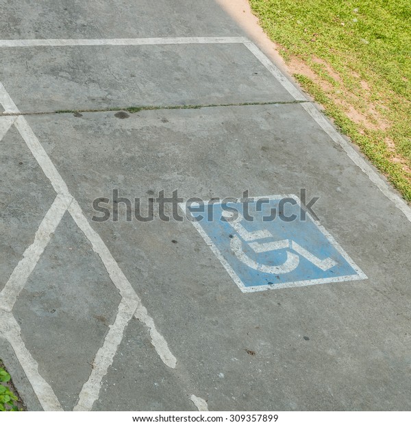 parking space reserved handicapped on road with\
disabled sign