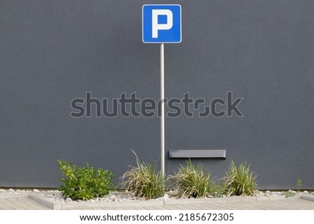 Parking space sign, in front of the building.