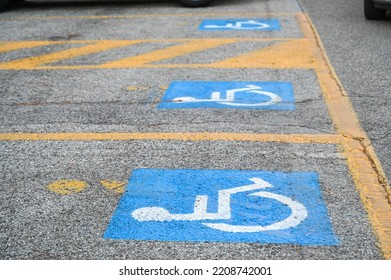 Parking space sign reserved for person with disability on the street. Wheelchair symbol on asphalt. 