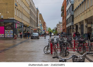 Parking spot for bicycles on front and cityscape view on background. Europe. Sweden. Uppsala. 05.21.2022.