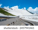 Parking spot for tourists snow mountains wall of Tateyama Kurobe alpine with blue sky background is one of the most important and popular natural place in Toyama Japan.